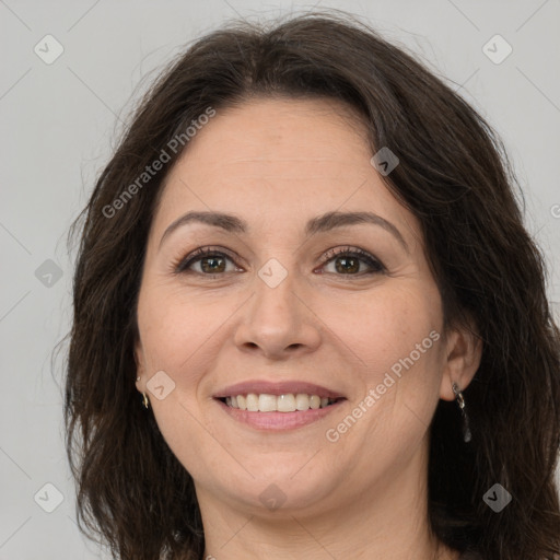 Joyful white adult female with long  brown hair and brown eyes