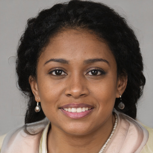 Joyful black young-adult female with long  brown hair and brown eyes
