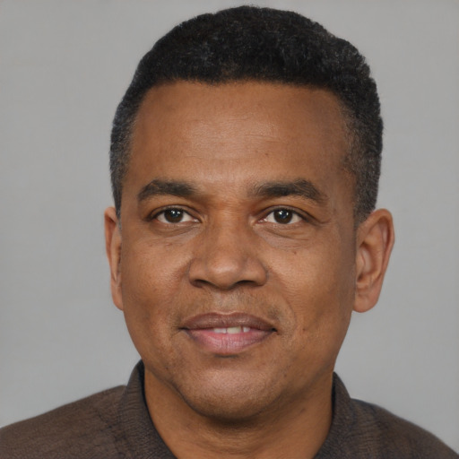 Joyful black adult male with short  black hair and brown eyes