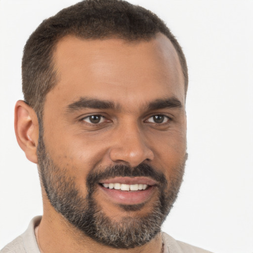 Joyful black young-adult male with short  brown hair and brown eyes