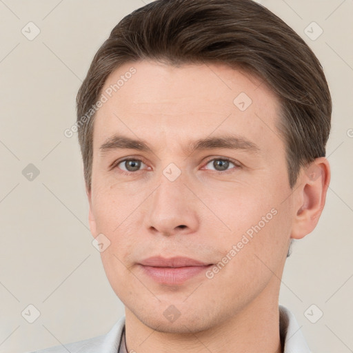 Joyful white young-adult male with short  brown hair and grey eyes