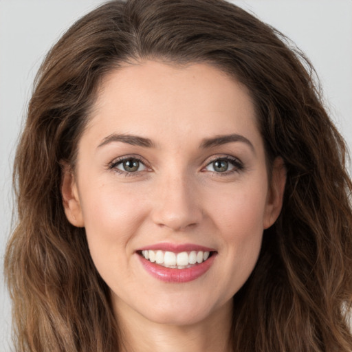 Joyful white young-adult female with long  brown hair and green eyes