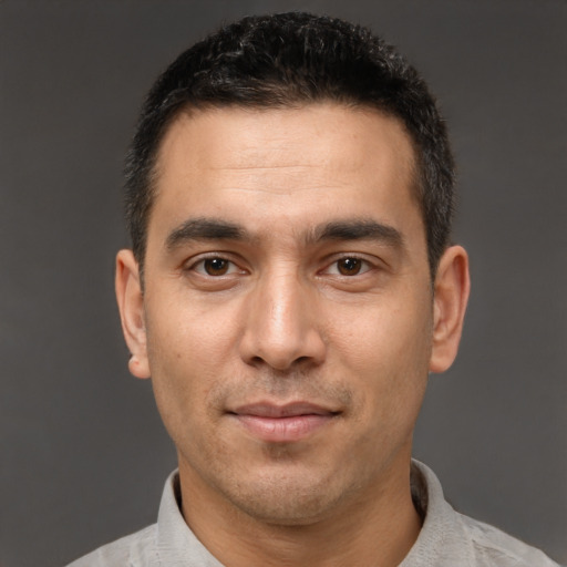 Joyful white young-adult male with short  black hair and brown eyes