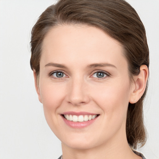 Joyful white young-adult female with medium  brown hair and grey eyes