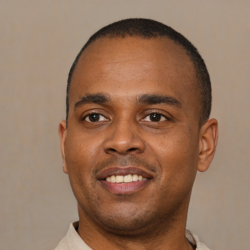 Joyful black young-adult male with short  black hair and brown eyes