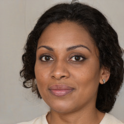 Joyful black adult female with medium  brown hair and brown eyes