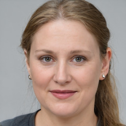 Joyful white adult female with medium  brown hair and grey eyes