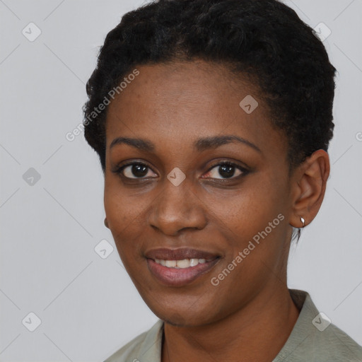 Joyful black young-adult female with short  black hair and brown eyes