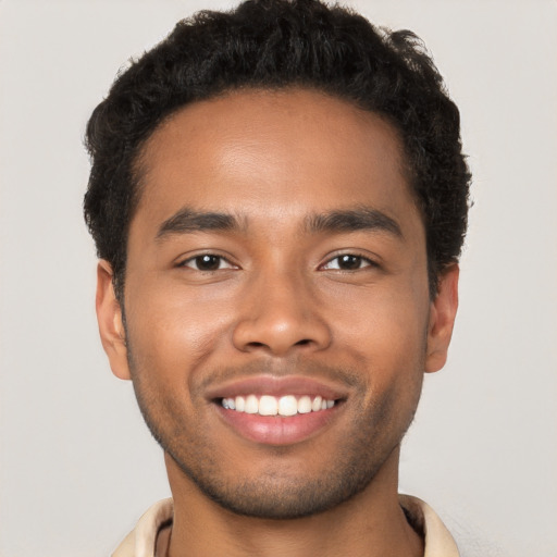 Joyful black young-adult male with short  brown hair and brown eyes