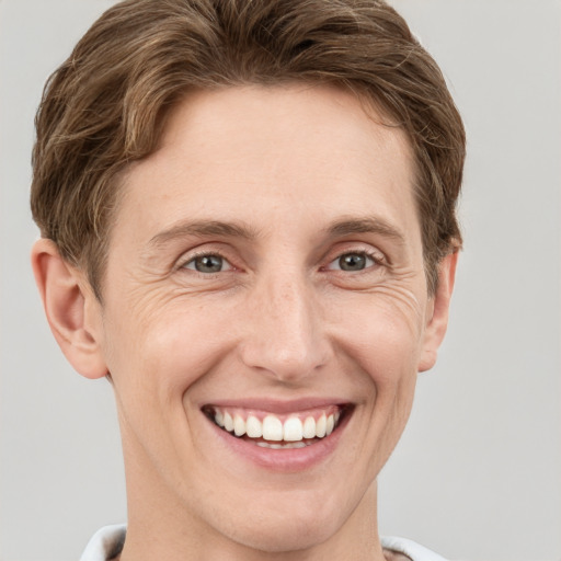 Joyful white adult male with short  brown hair and grey eyes