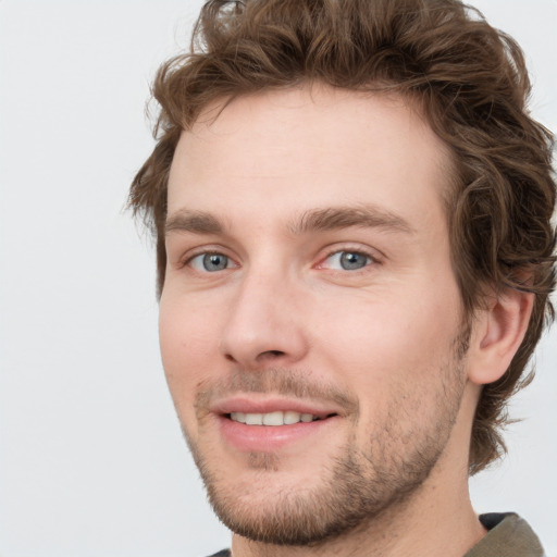 Joyful white young-adult male with short  brown hair and green eyes