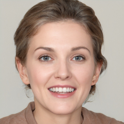 Joyful white young-adult female with medium  brown hair and grey eyes