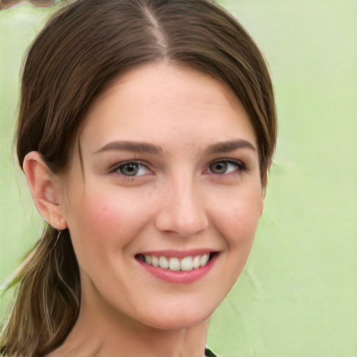 Joyful white young-adult female with long  brown hair and green eyes