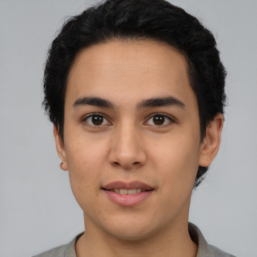 Joyful latino young-adult male with short  black hair and brown eyes