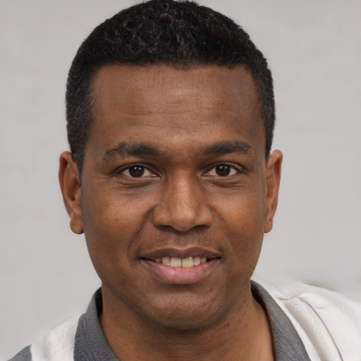 Joyful black young-adult male with short  black hair and brown eyes