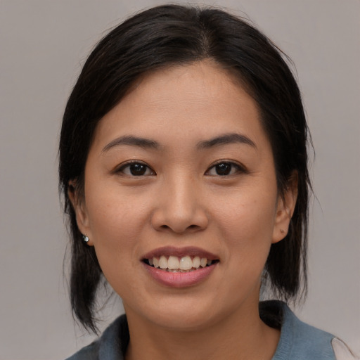 Joyful asian young-adult female with medium  black hair and brown eyes