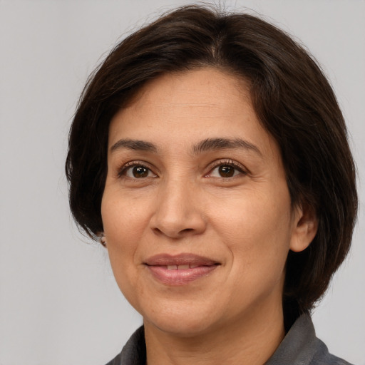 Joyful white adult female with medium  brown hair and brown eyes