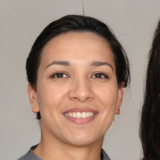 Joyful white young-adult female with long  brown hair and brown eyes