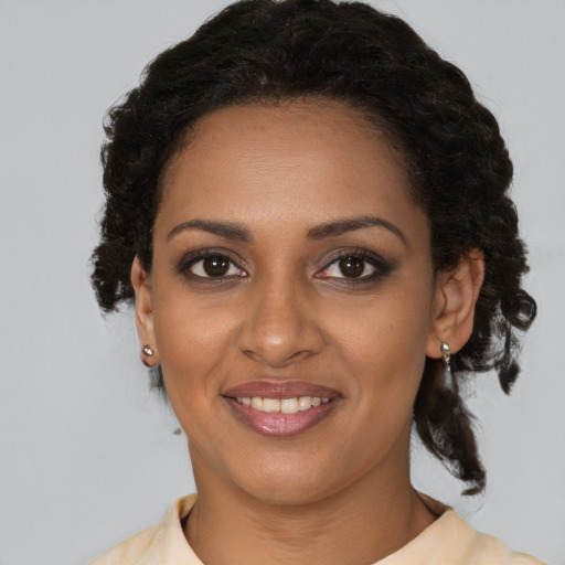 Joyful black young-adult female with medium  brown hair and brown eyes