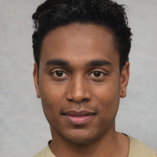 Joyful black young-adult male with short  black hair and brown eyes