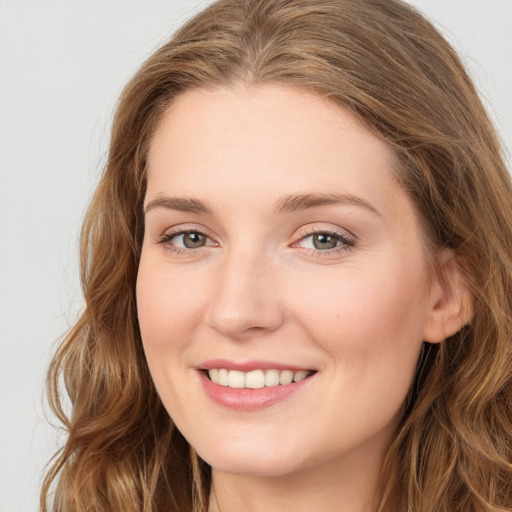 Joyful white young-adult female with long  brown hair and blue eyes