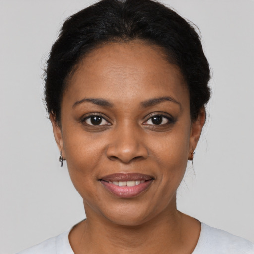 Joyful black young-adult female with short  black hair and brown eyes