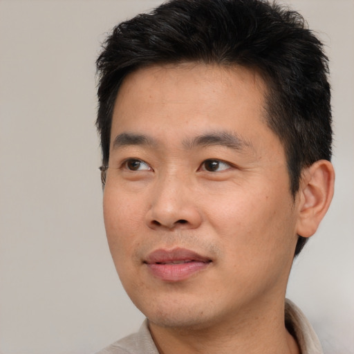 Joyful asian young-adult male with short  brown hair and brown eyes
