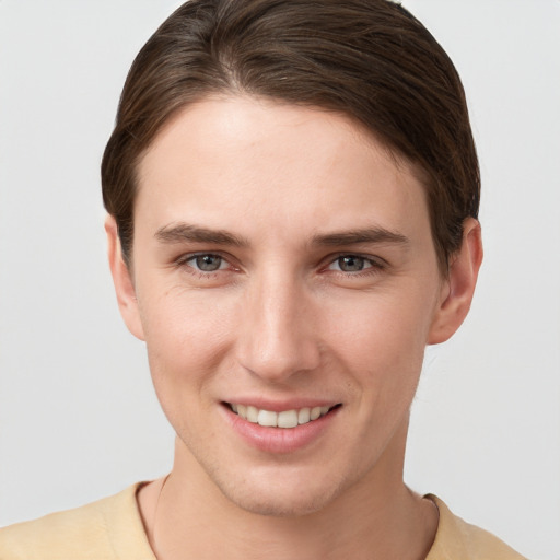 Joyful white young-adult female with short  brown hair and grey eyes