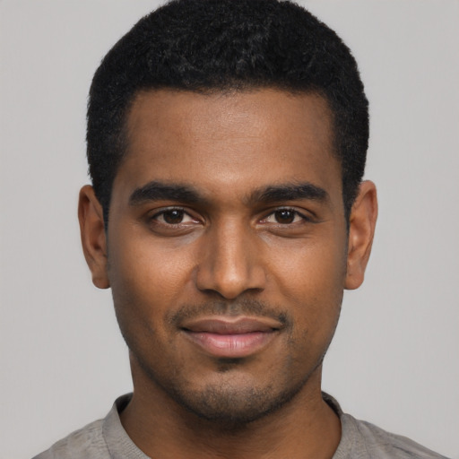 Joyful black young-adult male with short  black hair and brown eyes