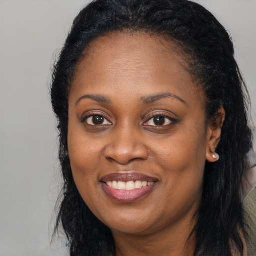 Joyful black adult female with long  black hair and brown eyes