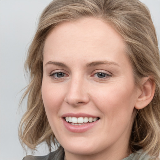 Joyful white young-adult female with medium  brown hair and blue eyes