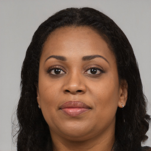 Joyful black young-adult female with long  black hair and brown eyes