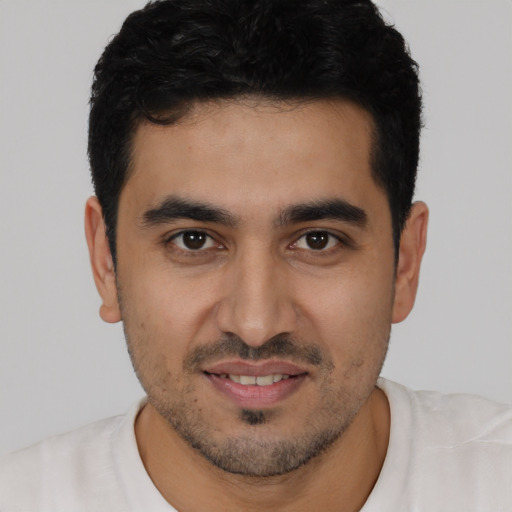 Joyful latino young-adult male with short  black hair and brown eyes