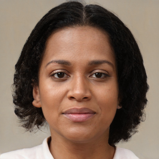 Joyful black young-adult female with medium  brown hair and brown eyes