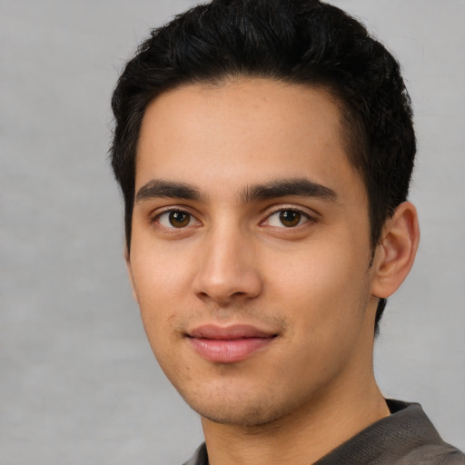 Joyful latino young-adult male with short  black hair and brown eyes