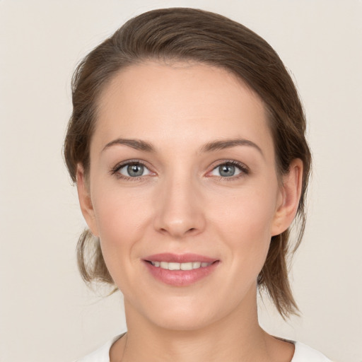 Joyful white young-adult female with medium  brown hair and grey eyes