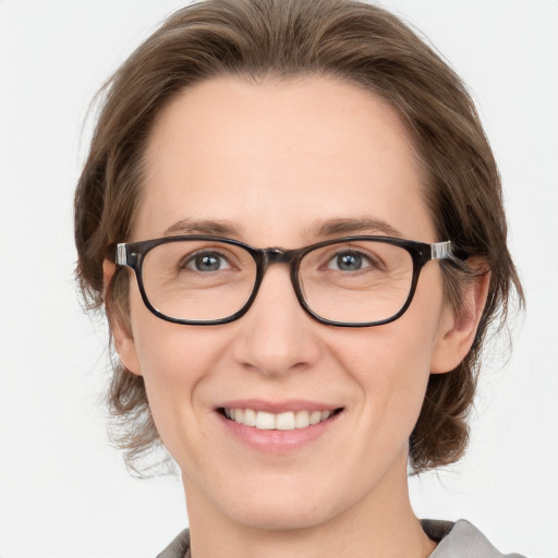 Joyful white adult female with medium  brown hair and grey eyes