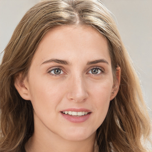 Joyful white young-adult female with long  brown hair and blue eyes