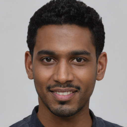 Joyful black young-adult male with short  black hair and brown eyes