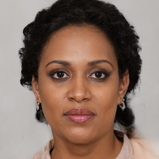 Joyful black adult female with medium  brown hair and brown eyes