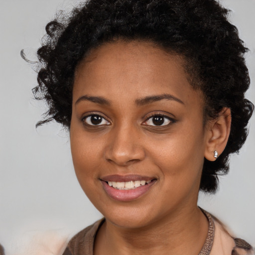 Joyful black young-adult female with medium  brown hair and brown eyes