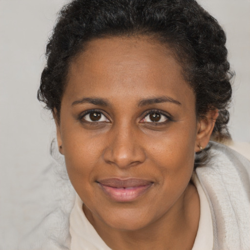 Joyful black young-adult female with short  brown hair and brown eyes