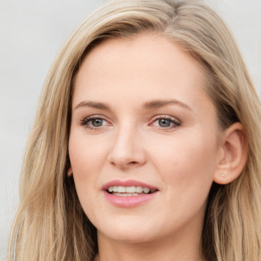 Joyful white young-adult female with long  brown hair and blue eyes