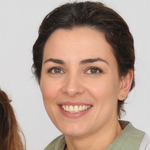 Joyful white young-adult female with medium  brown hair and brown eyes