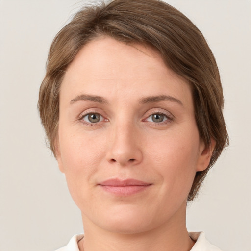 Joyful white young-adult female with short  brown hair and grey eyes