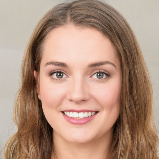 Joyful white young-adult female with long  brown hair and green eyes