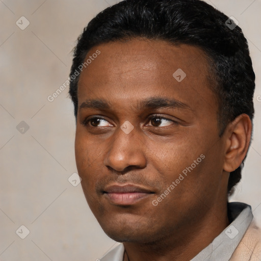 Joyful black young-adult male with short  black hair and brown eyes