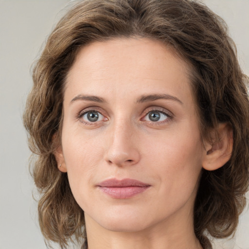 Joyful white young-adult female with medium  brown hair and green eyes