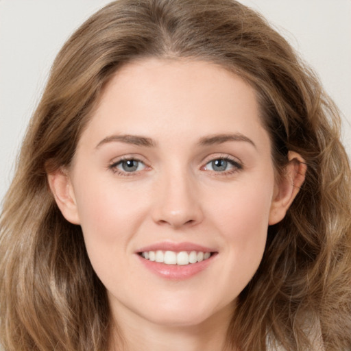 Joyful white young-adult female with long  brown hair and green eyes