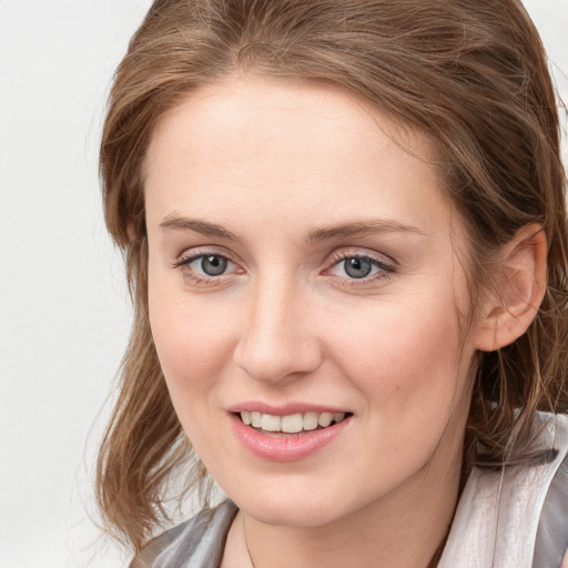 Joyful white young-adult female with long  brown hair and blue eyes